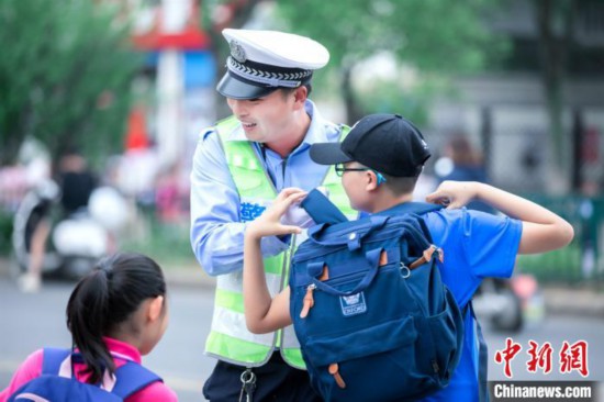 江苏一小学毕业照辅警“C位出道”背后：用爱心在付出