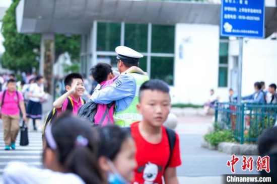 江苏一小学毕业照辅警“C位出道”背后：用爱心在付出