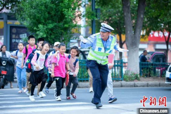 江苏一小学毕业照辅警“C位出道”背后：用爱心在付出