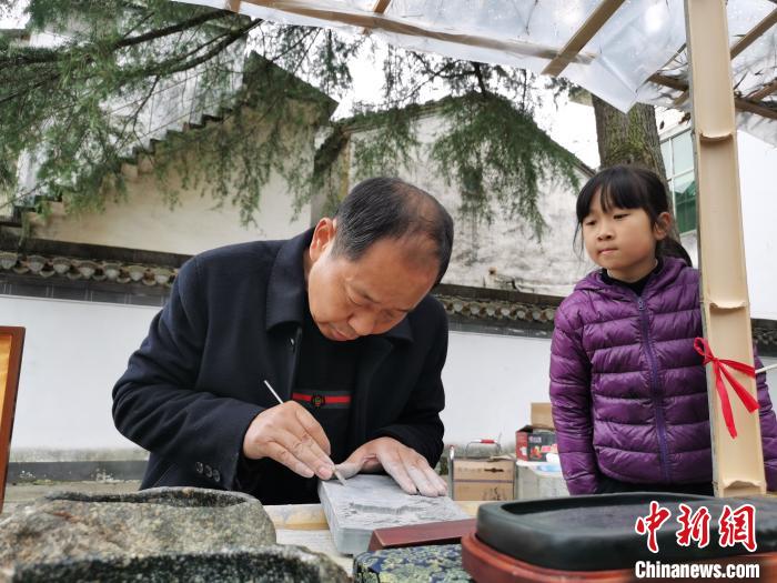 资料图：国家级非遗——徽州砖雕传承人向游客展示雕刻技艺。　张强摄