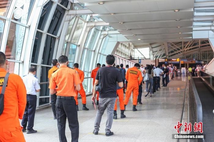 3月22日至26日，印尼旅游胜地巴厘岛伍拉莱国际机场将为约5000名员工全员进行首剂新冠疫苗接种，希望早日重迎国际游客的到来。图为3月22日，巴厘岛伍拉莱国际机场员工排队等待接种疫苗。<a target='_blank' href='http://www.chinanews.com/'><p  align=