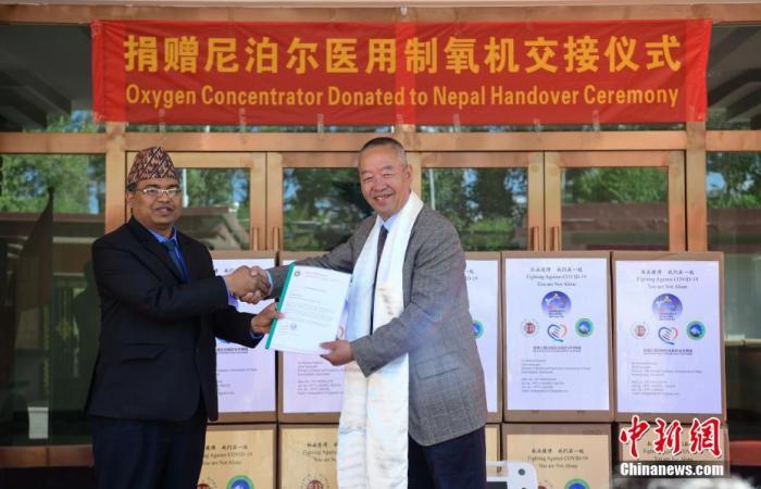 资料图:6月5日,中国西藏善缘基金会向尼泊尔捐赠医用制氧机交接仪式在拉萨举行。此次捐赠尼泊尔的抗疫医疗物资有60台5升医用制氧机,来自包括中国西藏善缘基金会、尼中凯拉斯文化发展促进会、四川省乐山市爱心人士的捐赠。图为尼泊尔驻拉萨总领事馆总领事纳瓦拉杰·达卡尔(左)和中国西藏善缘基金会理事长马志坚在交接仪式上合影。 <a target='_blank' href='http://www.chinanews.com/'><p align=