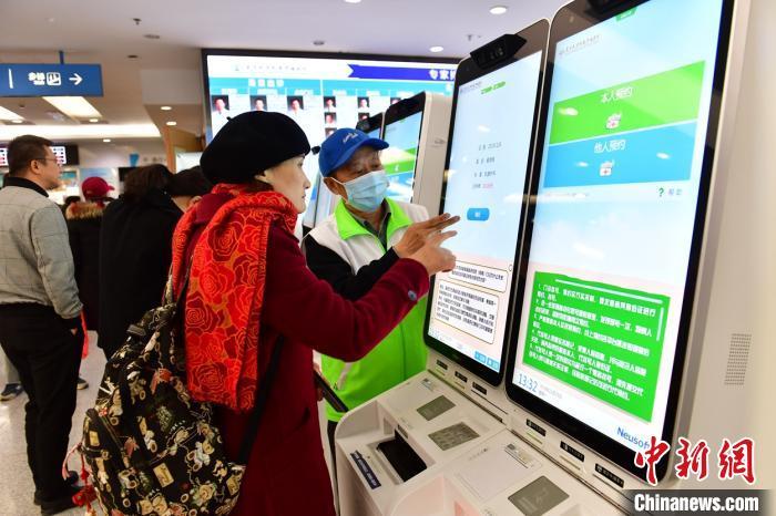  患者在指导下使用人脸识别系统预约专家号。　王广兆 摄